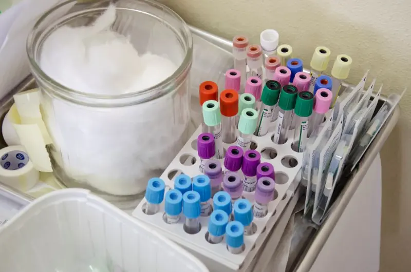 Reagensrør til å ha blodprøver i, ved siden av bomull